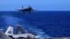 Dalam foto yang dirilis 31 Desember 2021 oleh Kantor Berita Xinhua, foto tak bertanggal menunjukkan jet tempur J-15 berbasis kapal induk bersiap untuk mendarat di kapal induk Liaoning milik angkatan laut China dalam latihan tempur di laut terbuka. (Hu Shanmin/Xinhua via AP)