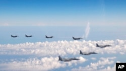 일본 자위대 소속 F-15 전투기 3대(앞)와 미군 F-16 전투기 4대가 지난달 25일 일본해(동해) 상공에서 기동하고 있다. (자료사진)