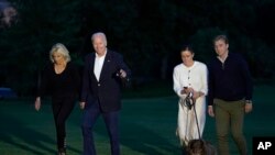 FILE - President Joe Biden and fist lady Jill Biden, left, walk with their granddaughter Naomi Biden, second from right, and her fiancé Peter Neal, right, and Neal's dog Charlie, across the South Lawn of the White House in Washington, June 20, 2022.