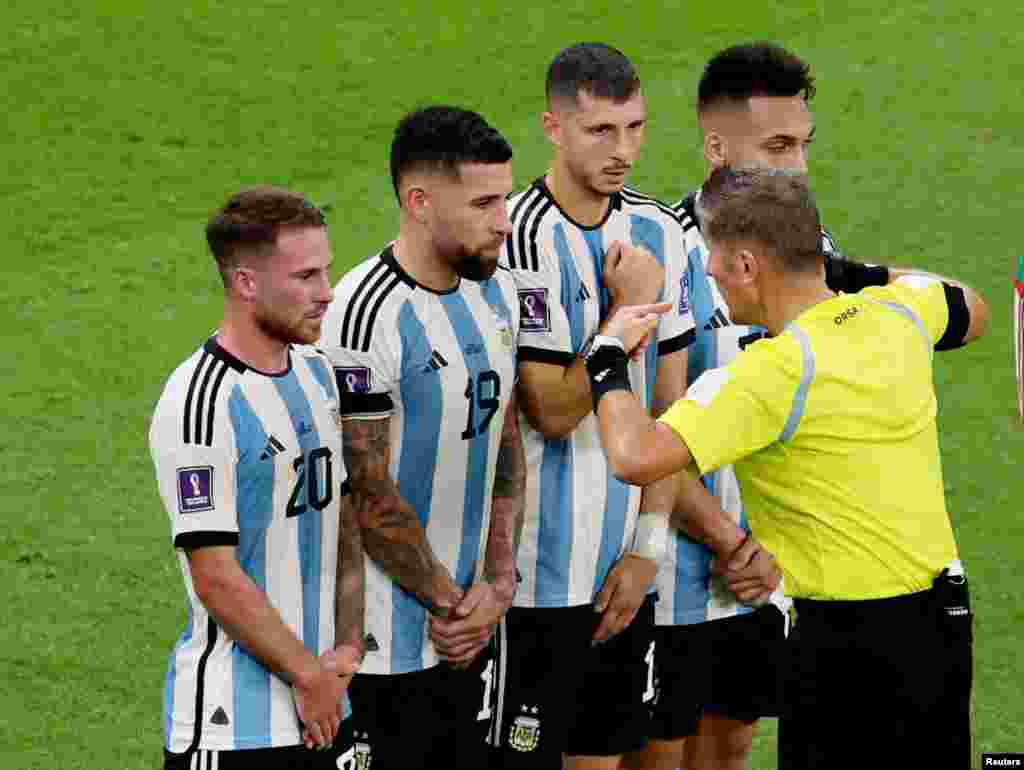 Abit Daniele Orsato pale ak jwe Ajanten Alexis Mac Allister, Nicolas Otamendi, Guido Rodriguez ak Lautaro Martinez pandan yap defann yon tir lib pandan match seleksyon nasyonal la kont Meksik nan Mondyal Foutbol Qatar la, 26 Nov. 2022.