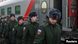 Russian conscripts called up for military service walk along a platform before boarding a train as they the depart for garrisons at a railway station in Omsk, Russia Nov. 27, 2022.