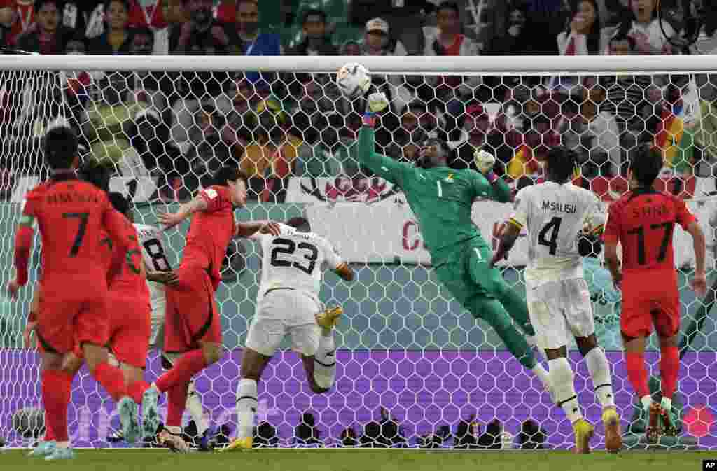 Gadyen Ghana a, Lawrence Ati-Zigi (mitan) anpeche balon an antre nan file a pandan match Gwoup H seleksyon nasyonal la kont Kore di Sid, 28 Nov. 2022.