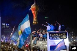 Tim sepak bola Argentina, Juara Piala Dunia 2022, tiba di tempat latihan di mana mereka akan bermalam setelah mendarat di bandara Ezeiza di pinggiran Buenos Aires, Argentina, Selasa, 20 Desember 2022. (AP Photo/Rodrigo Abd )