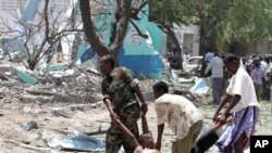 Somalian government soldiers carry a man killed during a suicide attack in Somalia's capital Mogadishu, October 4, 2011.
