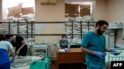 FILE - Medical staff tend to children in a room protected by sandbags at the Zaporizhzhia Regional Clinical Children's Hospital on March 22, 2022. 