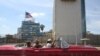 FILE - Tourists ride in a vintage car in front of the U.S. Embassy in Havana, Cuba, March 17, 2016.