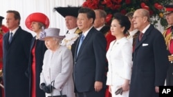 Britain's Queen Elizabeth II, in hat, stands with Chinese President Xi Jinping, his wife, Peng Liyuan and Prince Philip during the ceremonial welcome for the Chinese state visit, in London, Oct. 20, 2015.