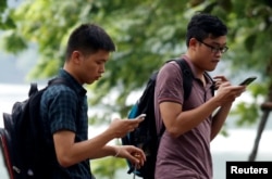 People play "Pokemon Go" by Hoan Kiem Lake in Hanoi, Vietnam, Aug. 18, 2016.
