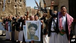 FILE - Shi'ite rebels, known as Houthis, hold a poster of Hezbollah leader Sheikh Hassan Nasrallah during a rally in support of Iranian-backed Hezbollah, in Sana'a, Yemen, March 3, 2016.