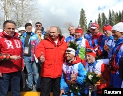 FILE - Russian President Vladimir Putin poses for a picture with Russian athletes who won the cross-country skiing open relay at the 2014 Sochi Winter Paralympic Games, March 15, 2014.