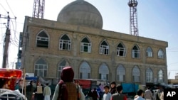 This frame grab image from video, shows a Taliban fighter standing guard outside the site of a bomb explosion inside a mosque, in Mazar-e-Sharif province, Afghanistan, April 21, 2022. 