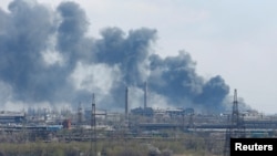Asap tampak keluar dari area pabrik besi dan baja Azovstal yang terletak di Mariupol, Ukraina, pada 20 April 2022. (Foto: Reuters/Alexander Ermochenko)