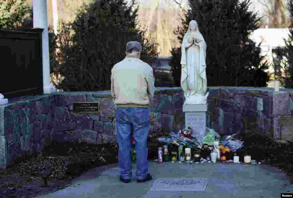Seorang laki-laki menundukkan kepalanya saat mengheningkan cipta untuk mengenang para korban penembakan di luar gereja Roma Katholik Santo Rosa dari Lima di Newtown, Connecticut, 15 Desember 2012.