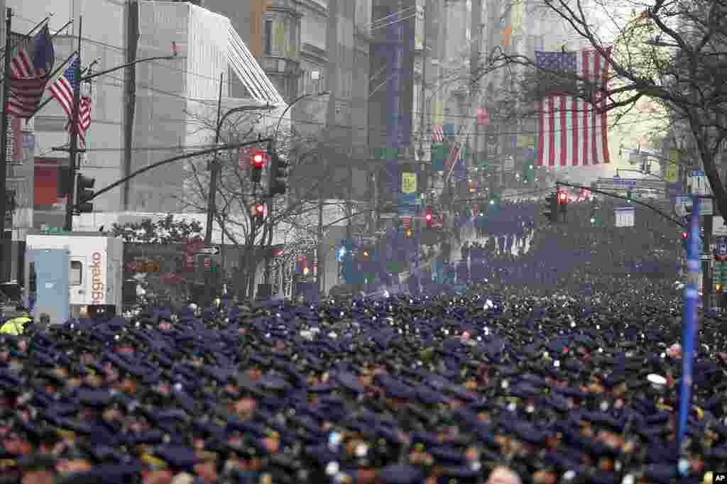 New York Police officers gather along Fifth Avenue for the funeral of Officer Jason Rivera, outside St. Patrick&#39;s Cathedral in New York. Rivera and his partner, Officer Wilbert Mora, were fatally wounded when a gunman ambushed them in an apartment last week.