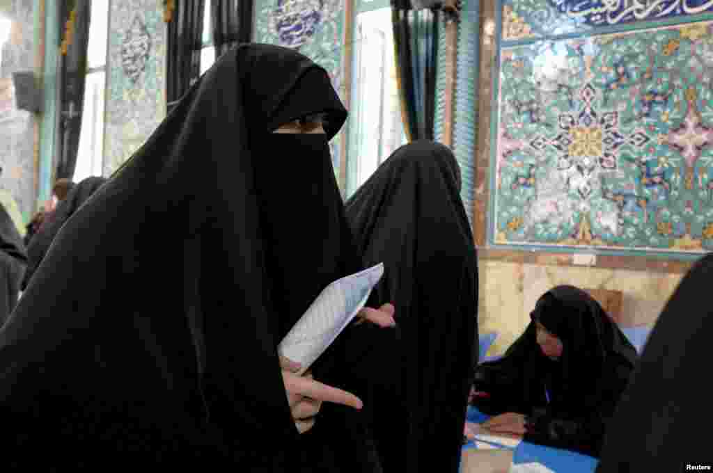 An Iranian woman casts her ballot during elections for the parliament and Assembly of Experts, which has the power to appoint and dismiss the supreme leader, in Tehran, Feb. 26, 2016.