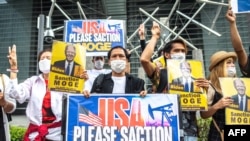 FILE - Aksi protes sekelompok aktivis Myanmar dengan membawa plakat, menyerukan pemerintah AS agar memberikan sanksi kepada Perusahaan Minyak dan Gas Myanma milik negara Myanmar menjelang kunjungan Presiden AS Joe Biden ke Jepang, di Tokyo, 22 Mei 2022.