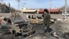 Un homme passe devant des voitures incendiées sur le site d'une frappe de missile, dans une gare, à Kramatorsk, en Ukraine, le 8 avril 2022.