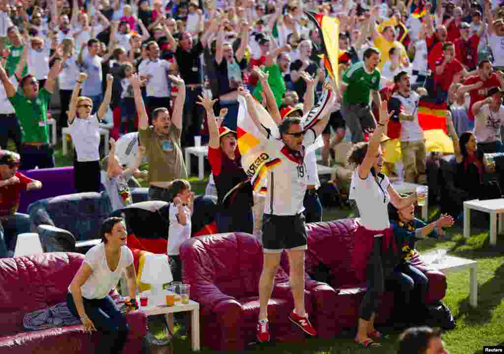 People celebrate a German goal as they watch the team playing against Portugal in a World Cup soccer match at a public viewing event at the Alte Foersterei stadium in Berlin.