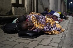 Des évacués de la ville de Goma ont passé la nuit dans une rue près de la frontière entre la RDC et le Rwanda à Gisenyi, au Rwanda, le 23 mai 2021.