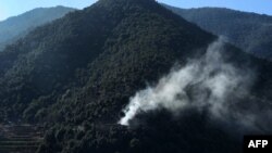 FILE - Smoke rises from a hillside in Afghanistan's eastern Kunar province, Jan. 17, 2015.
