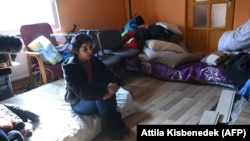 A woman sits in a house of the local Roma community as Romani people fleeing Ukraine crossed the Ukrainian-Hungarian border in Tiszabecs, Hungary. (Attila Kisbenedek/AFP)