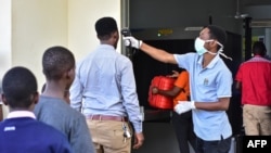 Mhudumu wa afya amfanyia vipimo vya joto raia mmoja wa Tanzania kwenye mpaka wa nchi hiyo na Kenya mjini Namanga.