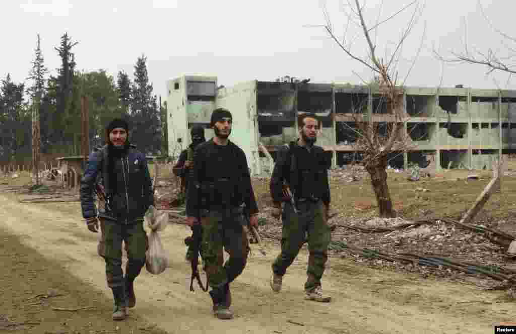 Laskar Suriah Bebas berjalan di pabrik farmasi Tameko setelah mengklaim mengambil alih pabrik, di timur al-Ghouta, dekat Damascus, 14 Januari 2014.
