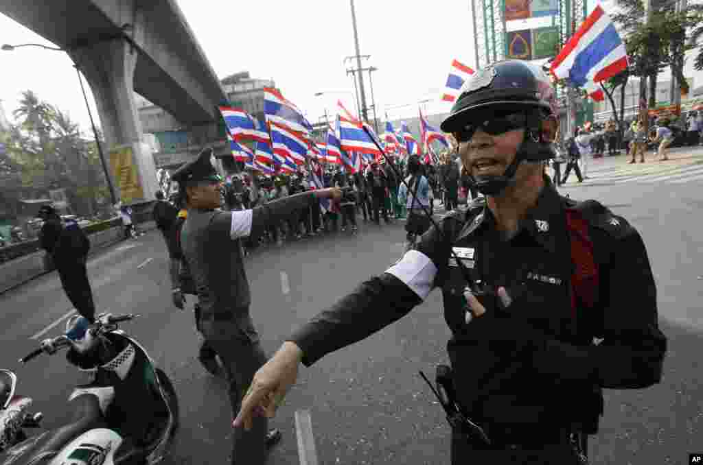 Police try to clear a main street for an anti-government protest march in Bangkok, Jan. 30, 2014.