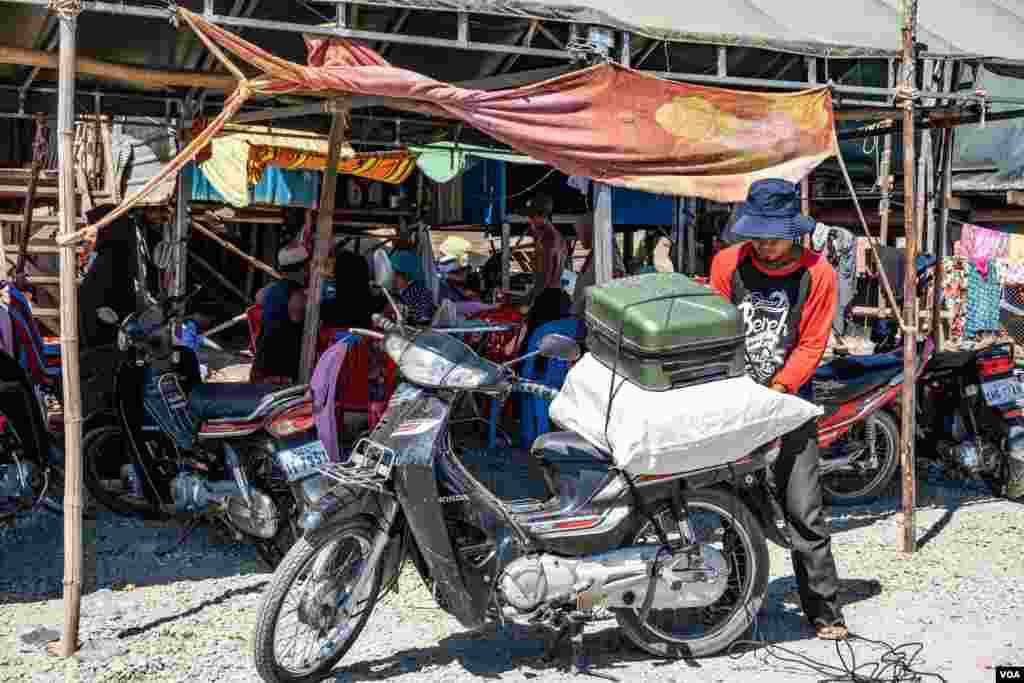 បុរសជនជាតិខ្មែរឥស្លាមម្នាក់ចងវ៉ាលីរបស់ខ្លួនជាមួយនឹងម៉ូតូបន្ទាប់ពីរដ្ឋបាលខណ្ឌជ្រោយចង្វារតម្រូវឲ្យពួកគេរុះរើសំណង់រោងរបស់ខ្លួននៅលើច្រាំងទន្លេសង្កាត់ជ្រោយចង្វារ ខណ្ឌជ្រោយចង្វារកាលពីថ្ងៃទី៣០ វិច្ឆិកា ឆ្នាំ២០១៩។(ទុំ ម្លិះ/VOA)