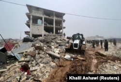 Tim penyelamat mencari korban selamat di bawah reruntuhan, menyusul gempa bumi, di Kota Jandaris yang dikuasai pemberontak, Suriah, 6 Februari 2023. (Foto: REUTERS/Khalil Ashawi)