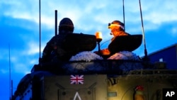 Britain's military officers sit on top of an armored vehicle at the Tapa Military Camp, in Estonia, Jan. 19, 2023. 
