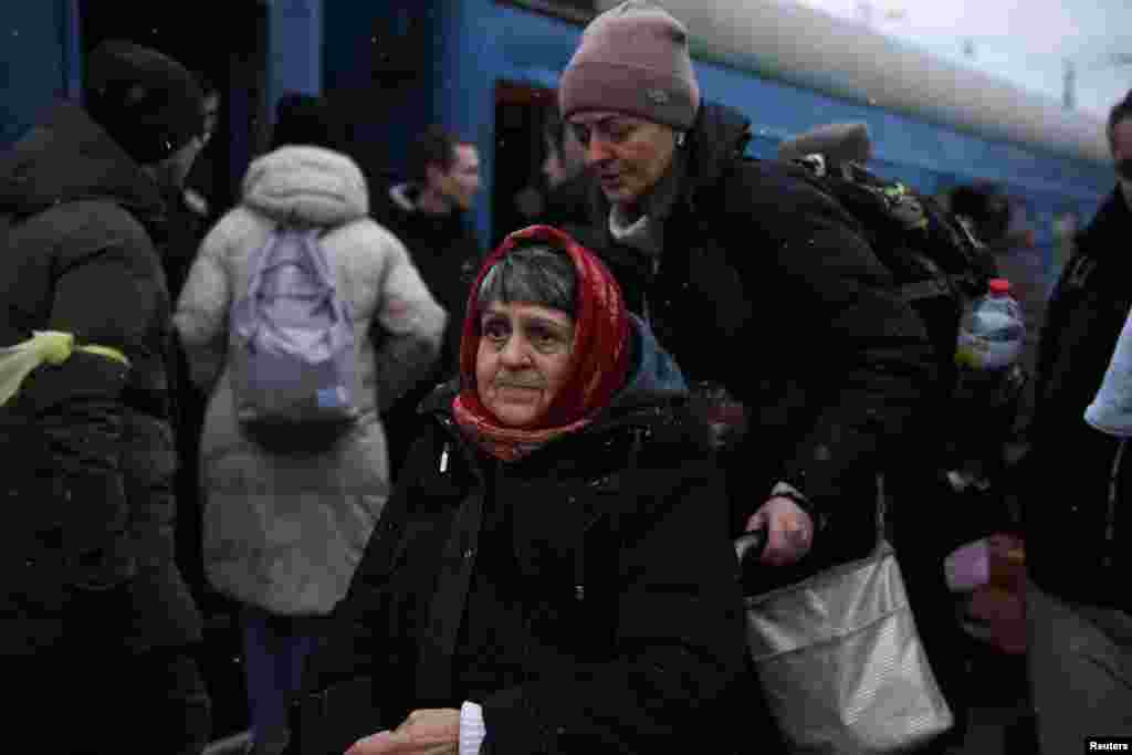 A woman on a wheelchair waits to board a train during snowfall, as civilians flee Russia's invasion of Ukraine, in Odessa, March 8, 2022.