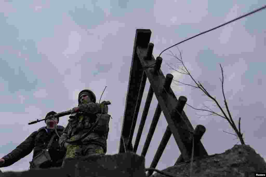 A Ukrainian service member stands as locals evacuate from the town of Irpin, March 7, 2022.