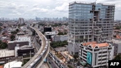 Kereta api dari sistem Mass Rapid Transit (MRT) melewati sebuah jalan di Jakarta, 10 Februari 2022. (BAY ISMOYO / AFP)