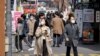 Orang-orang yang memakai masker berjalan di sebuah distrik perbelanjaan di tengah pandemi COVID-19 di Seoul, Korea Selatan, 16 Maret 2022. (Foto: Reuters)