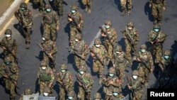 Tentara Myanmar dalam menghadapi protes warga di Yangon, Myanmar, 28 Februari 2021. Helikopter pemerintah Myanmar telah menyerang sebuah sekolah dan desa di bagian utara-tengah negara Asia Tenggara itu, menewaskan sedikitnya 13 orang termasuk tujuh anak-anak. (Foto: Reuters)
