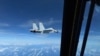 Sebuah jet tempur Angkatan Laut China J-11 terbang dekat dengan pesawat RC-135 Angkatan Udara AS di wilayah udara internasional di atas Laut China Selatan, 21 Desember 2022. (Foto: via Reuters )