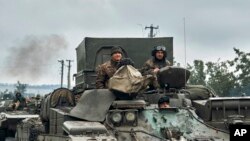 Kendaraan militer Ukraina bergerak di jalan di wilayah yang dibebaskan di wilayah Kharkiv, Ukraina, Senin, 12 September 2022. (AP/Kostiantyn Liberov).