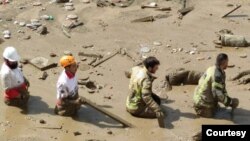 امدادگران گرفتار شده در گل و لای ناشی از سیل در یکی از شهرهای ایران.