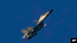 Sebuah jet tempur militer J-11 China terbang di atas Selat Taiwan dekat Pingtan, tanah terdekat daratan China ke Pulau Taiwan, di Pingtan di Provinsi Fujian, China tenggara, 5 Agustus 2022. (Foto: AP)