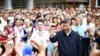 In this photo released by China's Xinhua News Agency, Chinese President Xi Jinping, center, visits the community of Guyuanxiang in the Tianshan District in Urumqi in northwestern China's Xinjiang Uyghur Autonomous Region, July 13, 2022. 