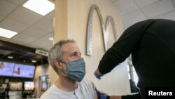 Seorang pria mendapatkan suntikan booster vaksin COVID-19 di sebuah gerai McDonald's di Chicago, AS, pada 21 Desember 2021. (Foto: Reuters/Jim Vondruska)