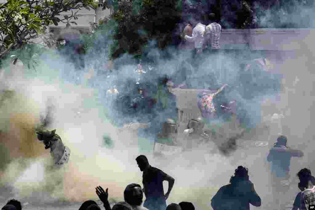 Army soldiers are caught in tear smoke with protesters storming the compound of Prime Minister Ranil Wickremesinghe's office in Colombo, July 13, 2022