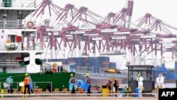 FILE - Workers disinfect an area at a port in Qingdao, in China's eastern Shandong province on July 13, 2022. 