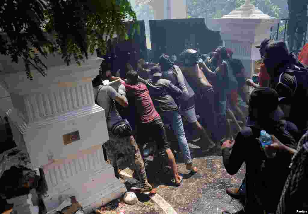 Demonstrators break the gate of Sri Lankan Prime Minister Ranil Wickremasinghe's office during a protest demanding for his resignation in Colombo, July 13, 2022.