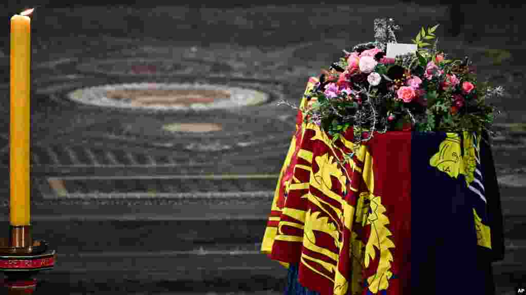 The coffin of Queen Elizabeth II, draped in the Royal Standard, is placed in Westminster Abbey in central London, for the funeral service, Sept. 19, 2022.