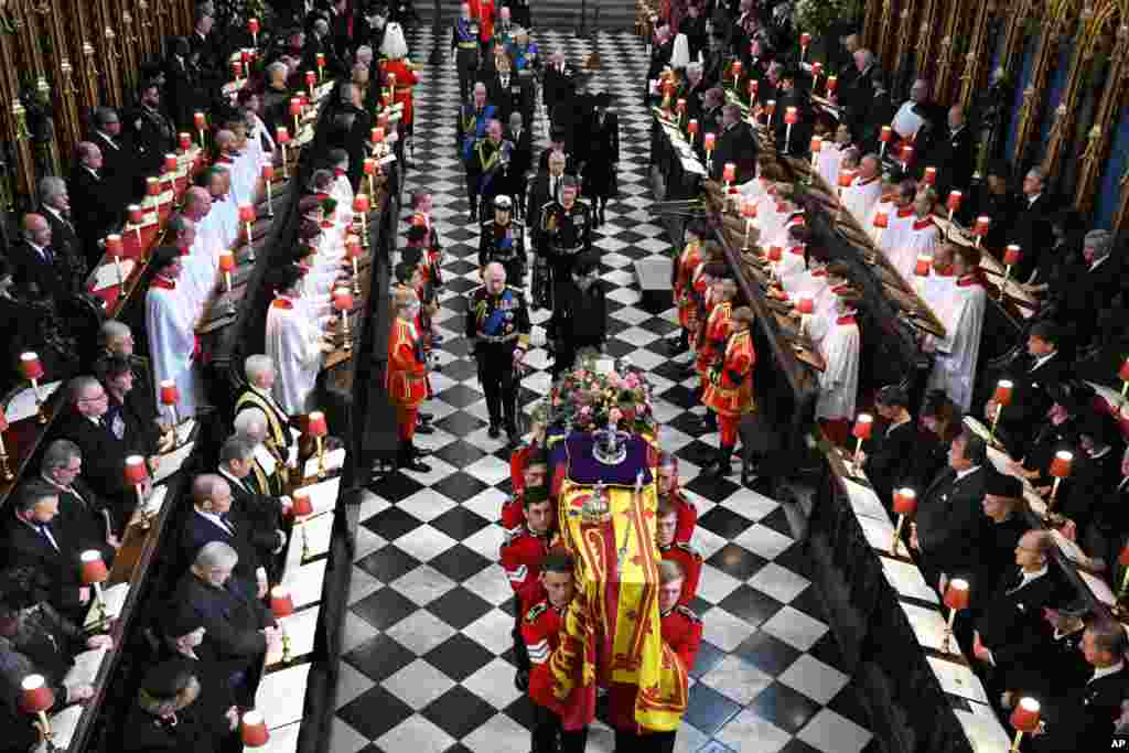 Back to front: Britain's King Charles III, front left, Camilla, Queen Consort, Princess Anne, Vice Admiral Timothy Laurence, Prince Andrew, Prince Edward, Sophie, Countess of Wessex, Prince William, Prince George Catherine, Princess of Wales, Prince Harry and Meghan, Duchess of Sussex walk behind the coffin of Queen Elizabeth as they leave Westminster Abbey in central London, Sept. 19, 2022. 