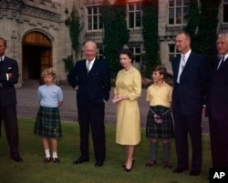 Ratu Inggris Elizabeth II berdiri di atas tanah Kastil Balmoral, di Royal Deeside, Skotlandia, antara Presiden AS Dwight D. Eisenhower dan Pangeran Charles, 29 Agustus 1959. (Foto: AP)