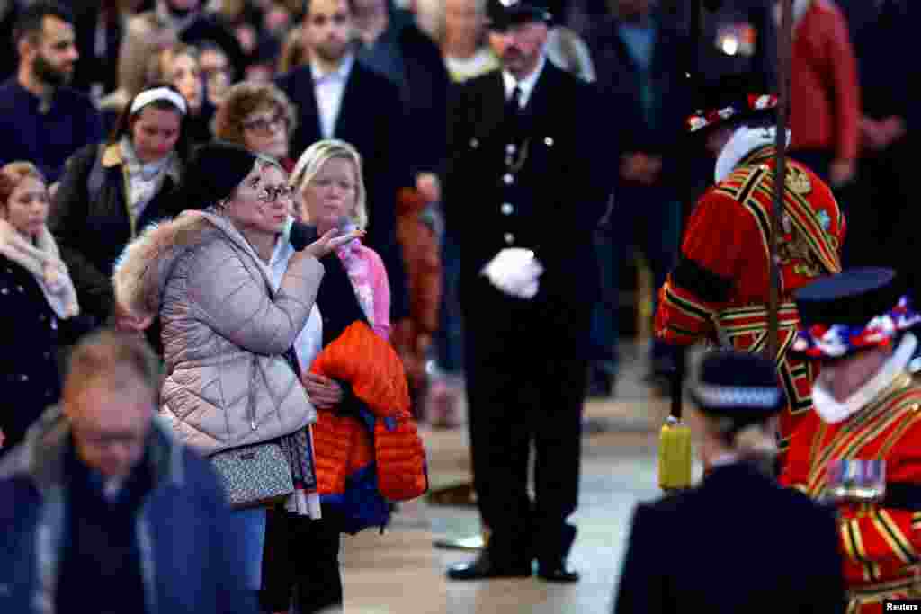 Members of the public pay their respects to Queen Elizabeth II's flag-draped coffin lying in state on the catafalque at Westminster Hall, Sept. 18, 2022 in London.