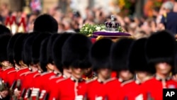 Mahkota imperial terlihat berada di atas peti jenazah Ratu Elizabeth II ketika peti dibawah dari Istana Buckingham menuju Westminster Hall di London, dalam sebuah prosesi pada 14 September 2022. (Foto: AP/Frank Augstein)